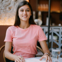 Writing dairy in note in coffee shop, concept as memory of life. Woman in coffee shop. Smiling woman making notes notepad.